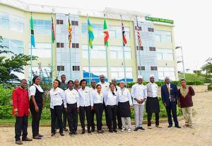 a group of people standing in front of a building with flags at A1 Hotel and Resort in Arusha