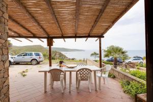 a patio with a table and chairs and a view of the ocean at La vista di Mondo in Torre Dei Corsari
