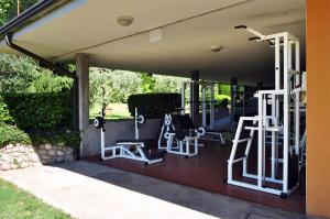 a gym with several equipment on a patio at Hotel Garden in Garda