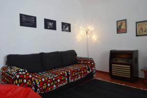 a living room with a black couch and a tv at Casa de S. Domingos in Évora