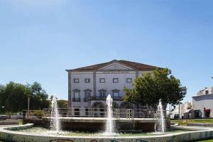 a building with a fountain in front of a building at Casa de S. Domingos in Évora