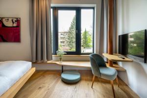 1 dormitorio con escritorio, 1 cama y ventana en numa l Drift Rooms & Apartments, en Berlín