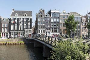 a bridge over a river in a city with buildings at Stylish Canalhouse A in Amsterdam