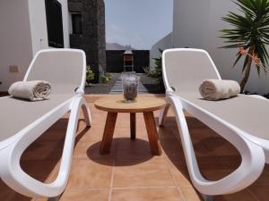 due sedie bianche e un tavolo in un cortile di Casa Marta, private pool, free WiFi a Playa Blanca