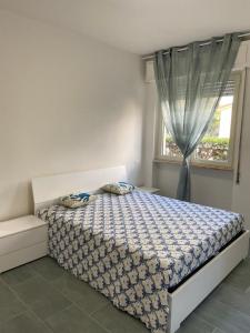 Schlafzimmer mit einem Bett und einem Fenster in der Unterkunft Appartamento completamente rinnovato, con giardino, a 100 mt dal mare in Marina di Massa