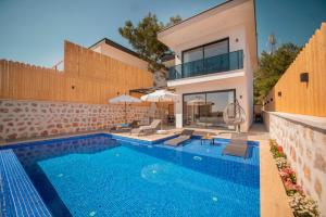 uma villa com uma piscina e uma casa em Emirbey - 2 Bedroom Holiday Villa with jacuzzi in Kalkan em Kas
