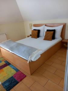 1 dormitorio con 1 cama grande con sábanas y almohadas blancas en Viola Vendégház en Pápa