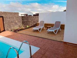 2 sedie sedute su una terrazza accanto alla piscina di Casa Marta, private pool, free WiFi a Playa Blanca