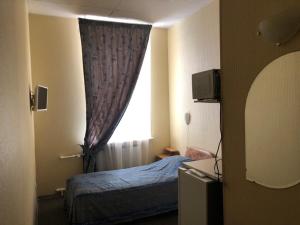 a hotel room with a bed and a window at Rinaldi at Bolshoy prospect in Saint Petersburg
