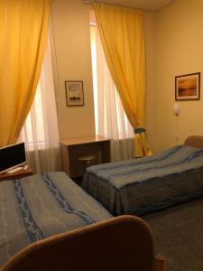 a hotel room with two beds and a window at Rinaldi at Bolshoy prospect in Saint Petersburg