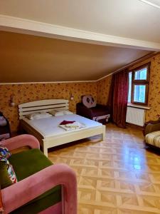 ein Schlafzimmer mit einem weißen Bett und einem Sofa in der Unterkunft Мини-отель in Kropywnyzkyj