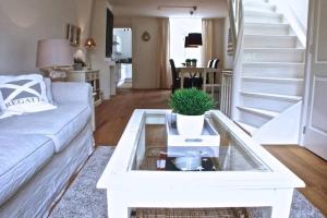 uma sala de estar com um sofá branco e uma mesa em Stylish Canalhouse B em Amsterdã