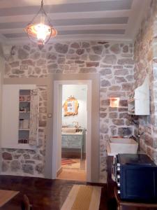 ein Badezimmer mit einer Steinmauer und einem Waschbecken in der Unterkunft 1836 Traditional House in Vathy