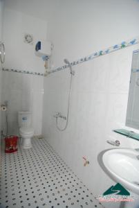 a bathroom with a shower and a toilet and a sink at Nhà nghỉ Dương Vũ in Mộc Châu