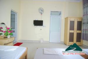 een kamer met een bed en een tv in een kamer bij Nhà nghỉ Dương Vũ in Mộc Châu