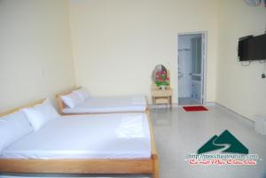 1 Schlafzimmer mit 2 Betten und einem TV an der Wand in der Unterkunft Nhà nghỉ Dương Vũ in Mộc Châu