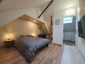sypialnia z dużym łóżkiem na poddaszu w obiekcie Ô’Mille’Lieux by Audrey & Thomas w mieście Provin