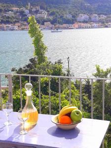 a bowl of fruit on a table with a bottle and glasses at 1836 Traditional House in Vathi