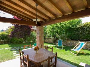 een houten tafel en stoelen onder een houten pergola bij Holiday Home Il Girasole by Interhome in Camaiore
