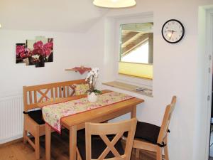 a dining room table and chairs with a clock on the wall at Apartment Ferienwohnung Lärche by Interhome in Oberwang
