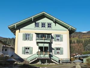 a large house with green and white at Apartment Stainer by Interhome in Neukirchen am Großvenediger