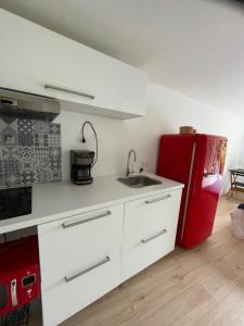 Una cocina con un fregadero y un refrigerador rojo. en Et c'est une autre histoire studio, en Léon 5 fotos más