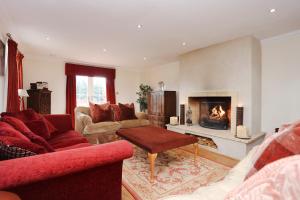 a living room with a couch and a fireplace at ALTIDO Greenknowes Estate - Retreat With Garden, Parking and Hot Tub in Kelty
