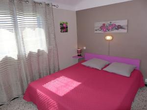 a bedroom with a pink bed in front of a window at Holiday Home Les Vives by Interhome in Narbonne-Plage