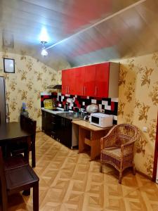 eine Küche mit roten Schränken sowie einem Tisch und Stühlen in der Unterkunft Мини-отель in Kropywnyzkyj