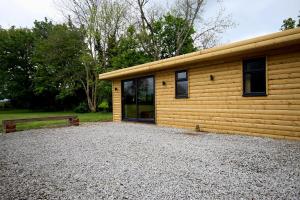 uma pequena cabana de madeira com um banco ao lado em Paull Holme Farm Bed and Breakfast em Paull