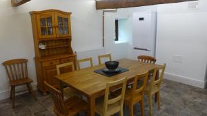 a dining room with a wooden table and chairs at Blaentwrch Farmhouse in Llanddewi-Brefi