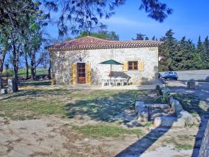 a small stone house with a table and chairs at Holiday Home Domaine La Batisse by Interhome in Lespignan