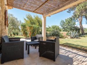 a patio with wicker chairs and a table at Holiday Home Domaine La Batisse by Interhome in Lespignan