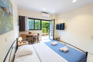 a bedroom with a large bed and a dining room at Fotis Apartments in Artemida