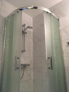 コウォブジェクにあるPoppy Apartment Kolobrzegのバスルーム(ガラスドア付きのシャワー付)