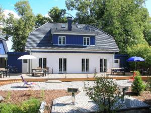a blue and white house with a patio at Holiday Home Boddenruhe by Interhome in Ummanz