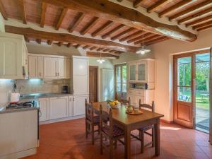 a kitchen with a table and chairs in a room at Holiday Home Casale il Giglio-2 by Interhome in Ciggiano