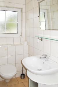 ツィノヴィッツにあるHoliday Home Im Kiefernweg by Interhomeの白いバスルーム(洗面台、トイレ付)