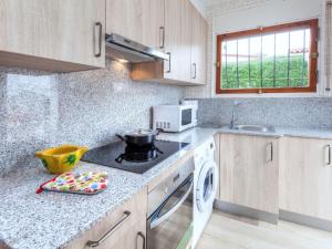 a kitchen with a stove top oven next to a microwave at Holiday Home La Llevantina by Interhome in L'Escala