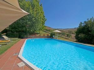 une grande piscine bleue avec un parasol dans l'établissement Villa Podere Agnese by Interhome, à Centeno