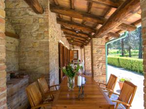 a wooden table with chairs and a vase of flowers at Villa Camporbiano by Interhome in Camporbiano