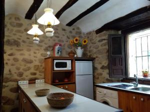 a kitchen with a white refrigerator and a sink at SOLAR de 1709 in Pradillo