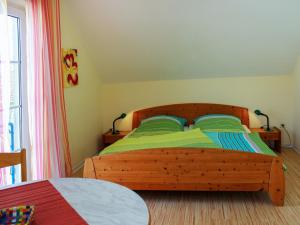 a bedroom with a wooden bed with green sheets at Holiday Home Lenzer Höh-1 by Interhome in Lenz