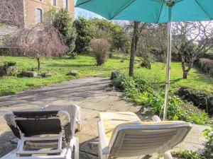 two chairs and an umbrella on a patio at Holiday Home Bella Vista by Interhome in Saint-Suliac