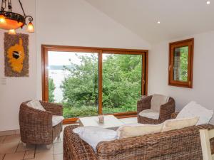 uma sala de estar com uma mesa e cadeiras e uma grande janela em Holiday Home Bella Vista - SSC100 by Interhome em Saint-Suliac