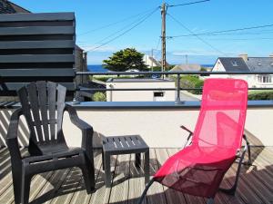 two chairs and a pink chair on a deck at Holiday Home Tal ar Mor by Interhome in Plouescat