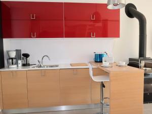 een keuken met rode kasten en een aanrecht met een wastafel bij Holiday Home Ty Angèle - PLC239 by Interhome in Plouescat