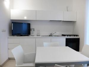 a kitchen with white cabinets and a table and a tv at Apartment Stella Marina by Interhome in San Salvo