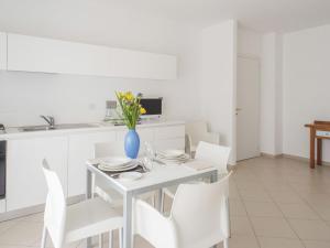 サン・サルヴォにあるApartment Stella Marina by Interhomeの白いキッチン(白いテーブル、白い椅子付)
