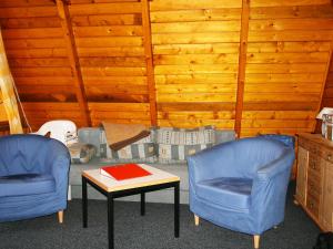Dos sillas azules y una mesa con un libro. en Chalet Nepumuk-3 by Interhome en Arendsee